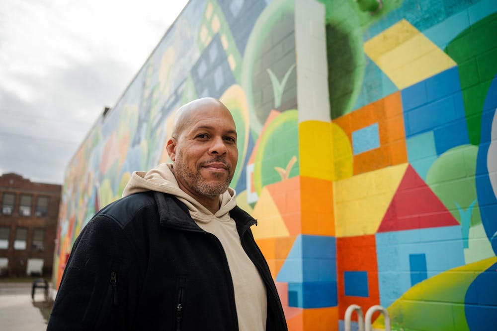 <p>Brian Whitfield stops for a portrait backdropped by his vibrant Allen Neighborhood Center mural on Feb. 23, 2024.</p>