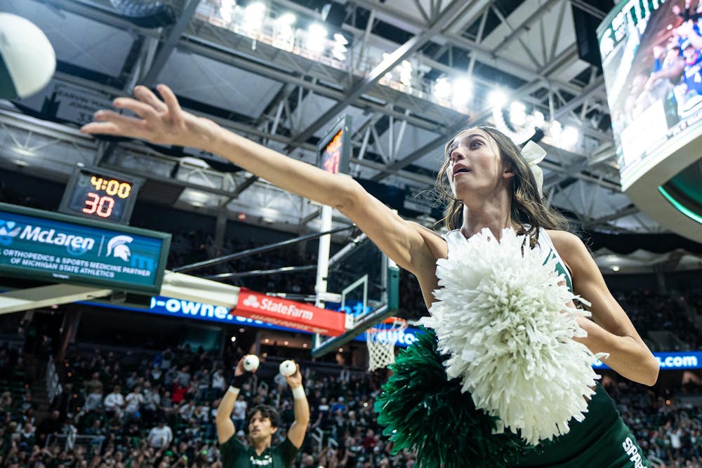 A Michigan State cheerleader tosses a toy basketball to the crowd during a game against the University of Washington at the Breslin Center in East Lansing, Michigan on January 9, 2025. Michigan State won 88-54. 