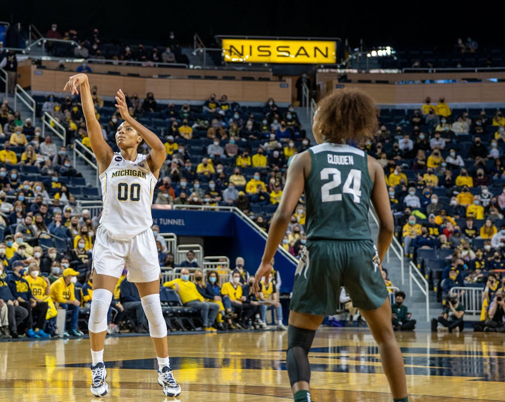 <p>Senior guard Nia Clouden (24) eyes senior forward Naz Hillmon as she shoots. Clouden had 22 points and Hillmon had 28 with both players living up to their expectations of prolific scorers. The Wolverines defeated the Spartans 62-51 at the Crisler Center on Feb 24., 2022.</p>