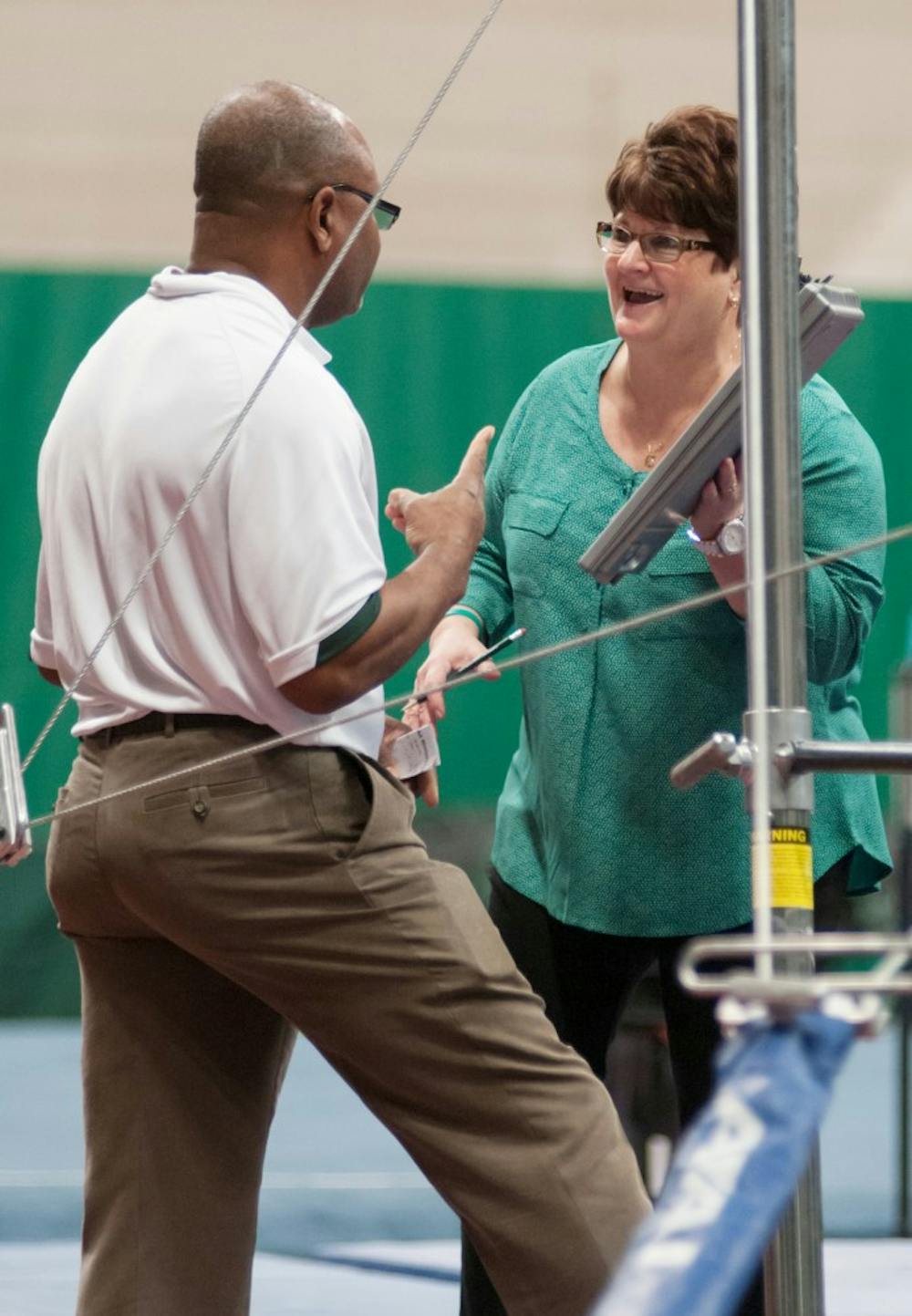 Head coach Kathie Klages and assistant coach Mo Mitchell of the MSU women's gymnastics team converse between events during a meet with Pittsburgh on Jan. 18, 2014, at Jenison Field House. Casey Hull/The State News