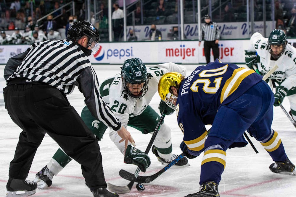 Sophomore Josh Nodler (20) faces off against a Notre Dame player during the first period. The Fighting Irish shutout the Spartans 2-0 on Feb. 27, 2021.