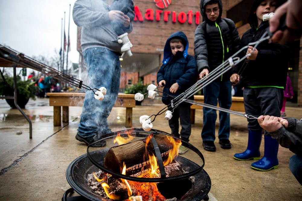 <p>People roast marshmallows during the annual Winter Glow Festival on Dec. 1, 2018 at Ann Street Plaza. The free festival featured carriage rides, music, a holiday farmers market and other seasonal activities.</p>