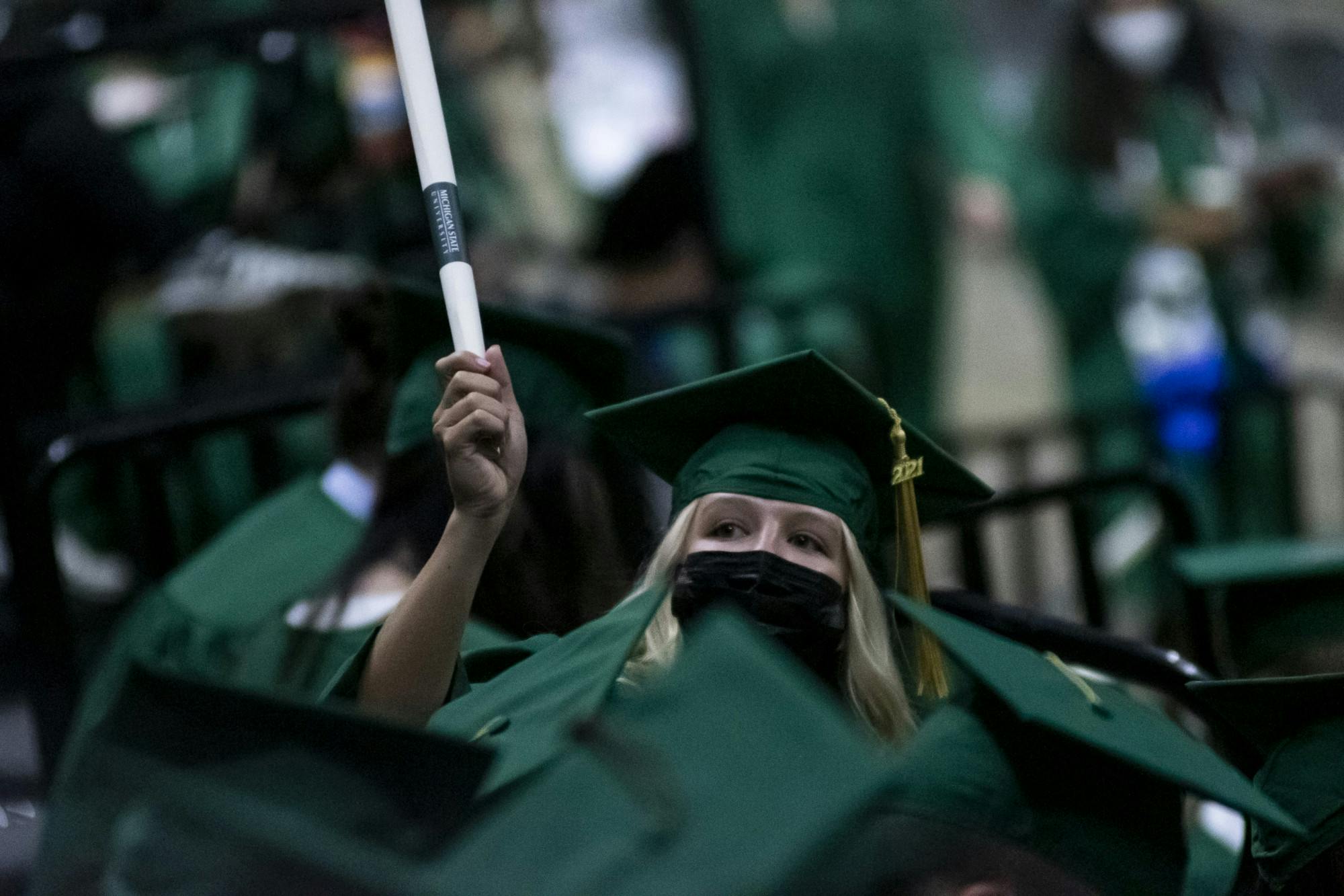 <p>A baccalaureate graduate with their diploma at the 2020 graduate and spring and summer 2021 graduate commencement ceremony at the Breslin Center on Sept. 18, 2021.</p>