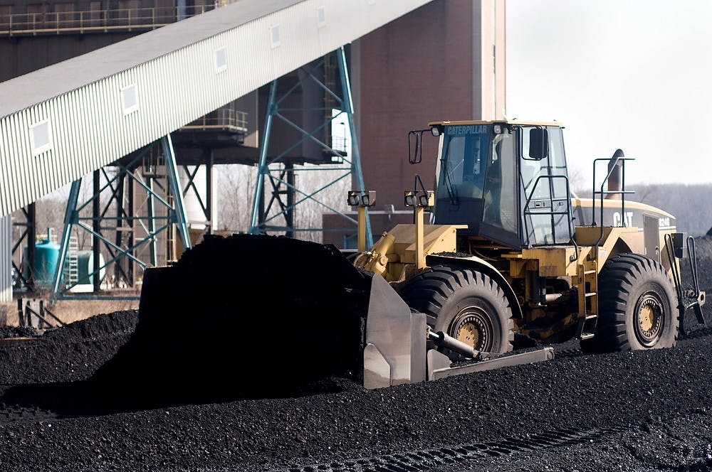 <p>Ernest Tisdale, a fuel systems operator III, pushes a pile of coal with a bulldozer March 16, 2011, at the T.B. Simon Power Plant. Behind the power plant, coal is dropped through grates either from trains or by bulldozer onto a conveyer belt where it is taken to the plant to be used. State News File Photo</p>