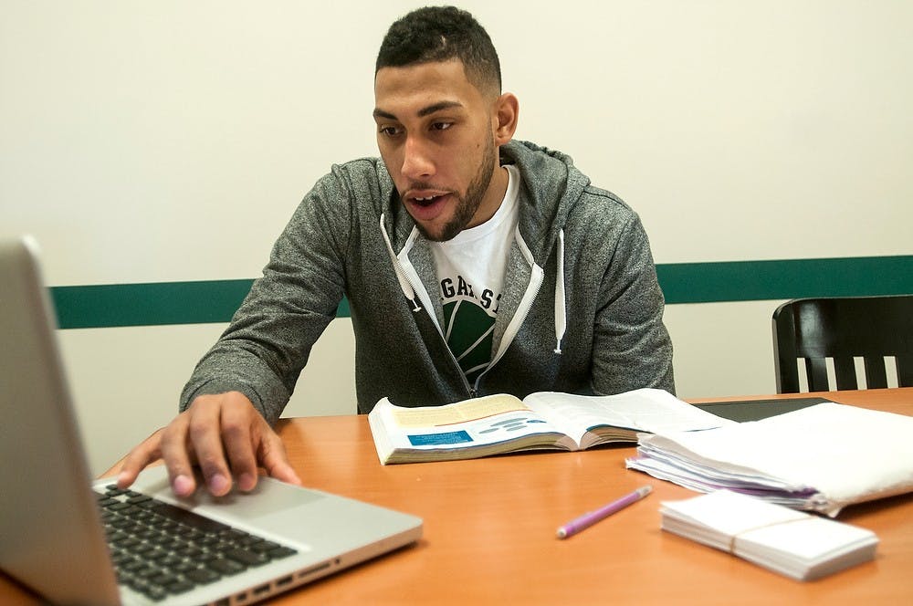 <p>Men's basketball junior guard Denzel Valentine studies on Oct. 23, 2014, at the Clara Bell Smith Student-Athlete Academic Center. He was studying for his Communication 225 class. Jessalyn Tamez/The State News </p>