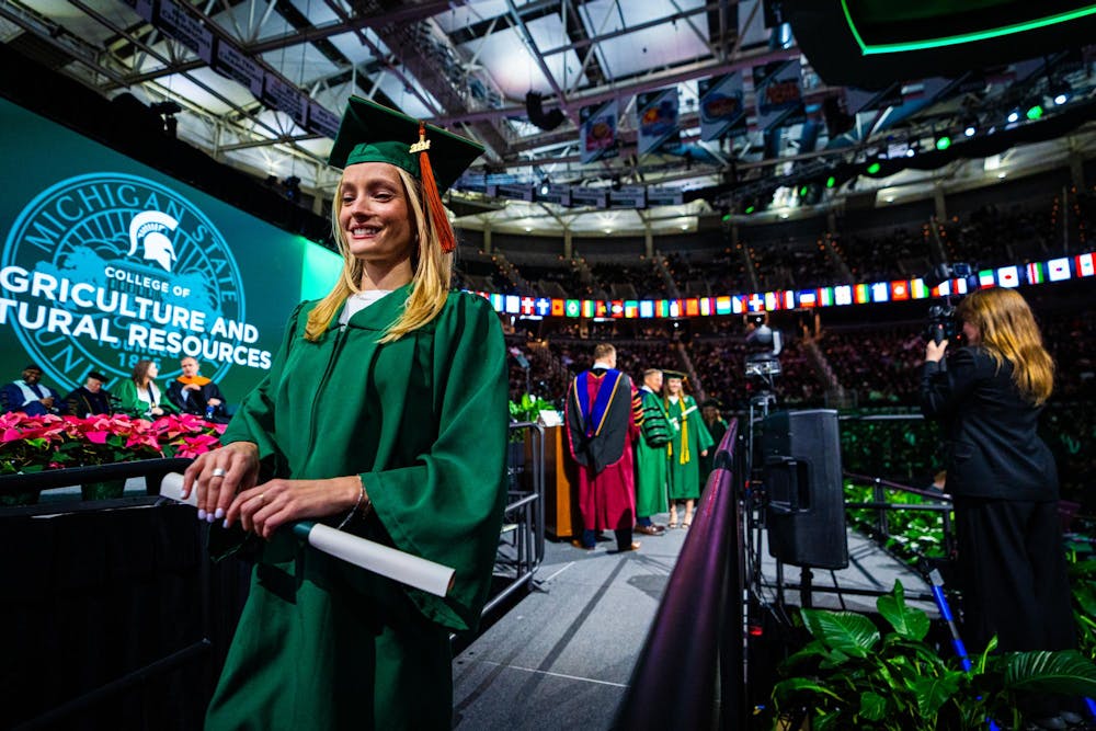 An MSU alumnus walks off stage with their diploma during the fall 2024 commencement ceremony at the Breslin Center on Dec. 14, 2024.