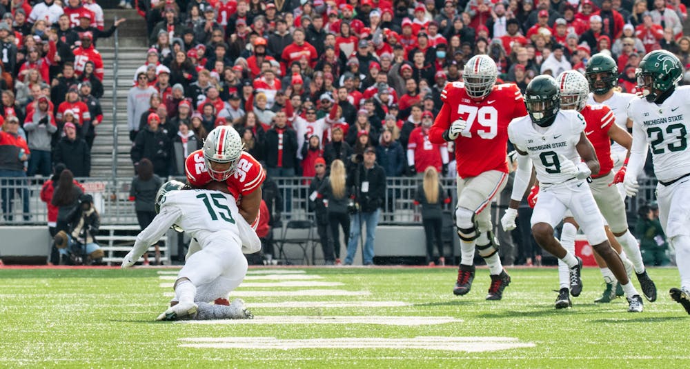 <p>Michigan State&#x27;s Angelo Grose (15) tackles Ohio State&#x27;s TreVeyon Henderson (32) during Michigan State&#x27;s loss to Ohio State on Nov. 20, 2021.</p>
