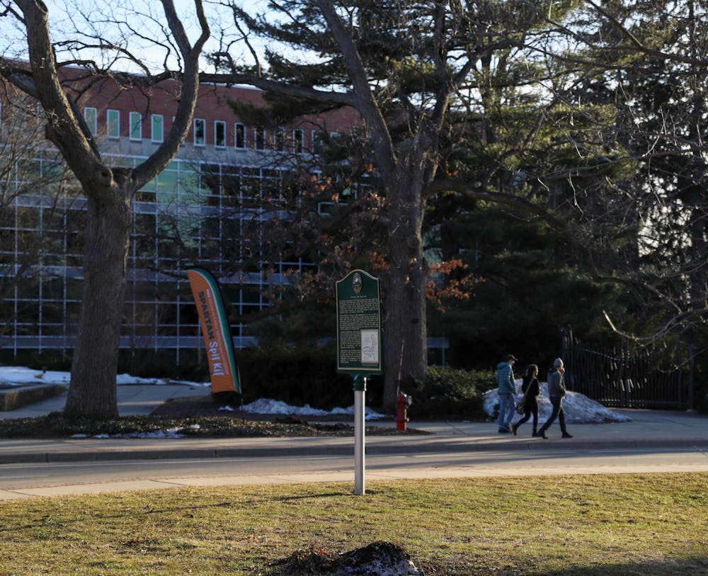 Mar. 7- East Lansing- People walking on campus to the right and on the left is a sign advertising "Spartan Spit." 
