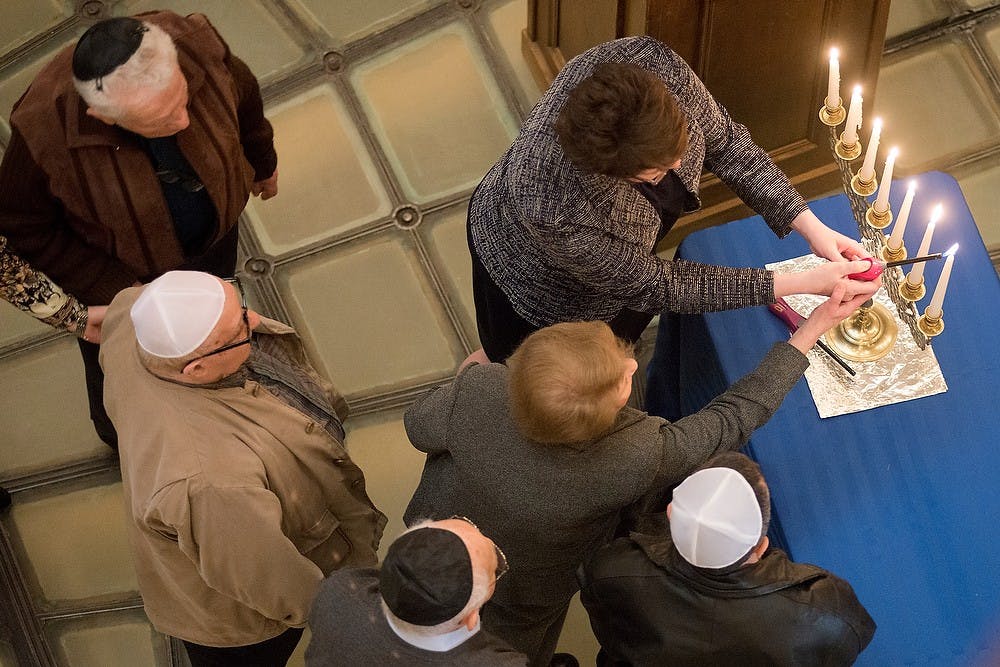 <p>Holocaust survivors light candles in remembrance April 24, 2014, during the Holocaust Commemoration Ceremony at the Capitol Building. Survivors joined many representatives and senators from across the state to light the candles. Julia Nagy/The State News </p>