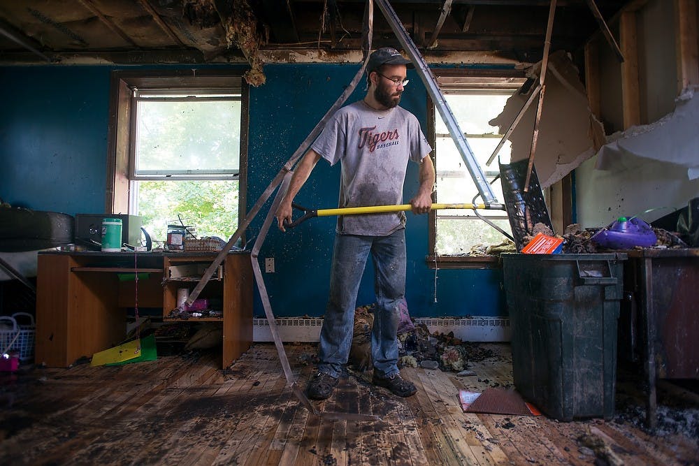 	<p>Gabe Purdy, with the Student Housing Cooperative, helps clean a room damaged by an early morning fire at Phoenix cooperative Sept. 4, 2013. Responders got a call at 3:02 a.m. about a fire which started in the back hallway of the second floor of the building. Julia Nagy/The State News</p>