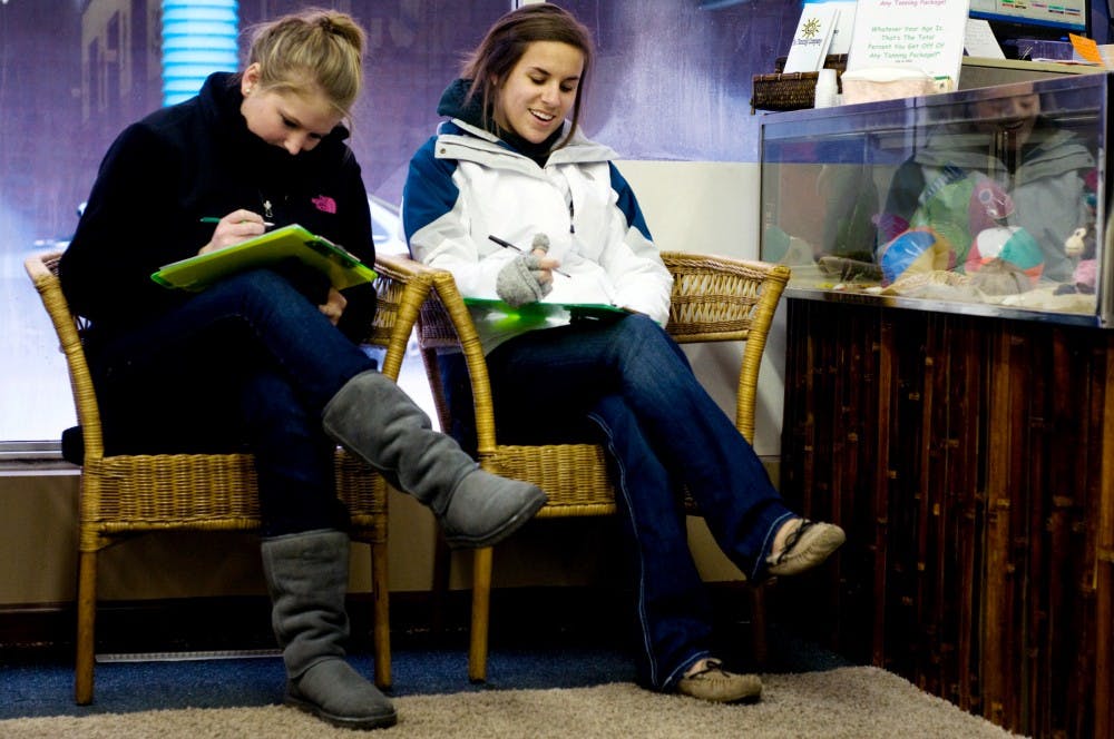 Pre-nursing freshman Katie Marti, right, and natural sciences freshman Chelsea Wegman fill out forms to purchase a tanning package in preperation for spring break Monday afternoon at The Tanning Company. With break just around the corner students across East Lansing are finializing travel plans and getting their bodies in spring break shape. Matt Hallowell/The State News