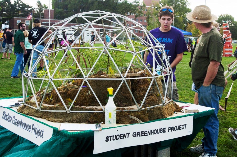 Kyle Ivester (left), a senior chemical engineering and voice performance major, speaks with Phillip Lamoureux (right) about the Student Greenhouse Project on Tuesday, Aug. 28 at Sparticipation. Lamoureux is the faculty advisor for the project. Griffin Zotter/The State News