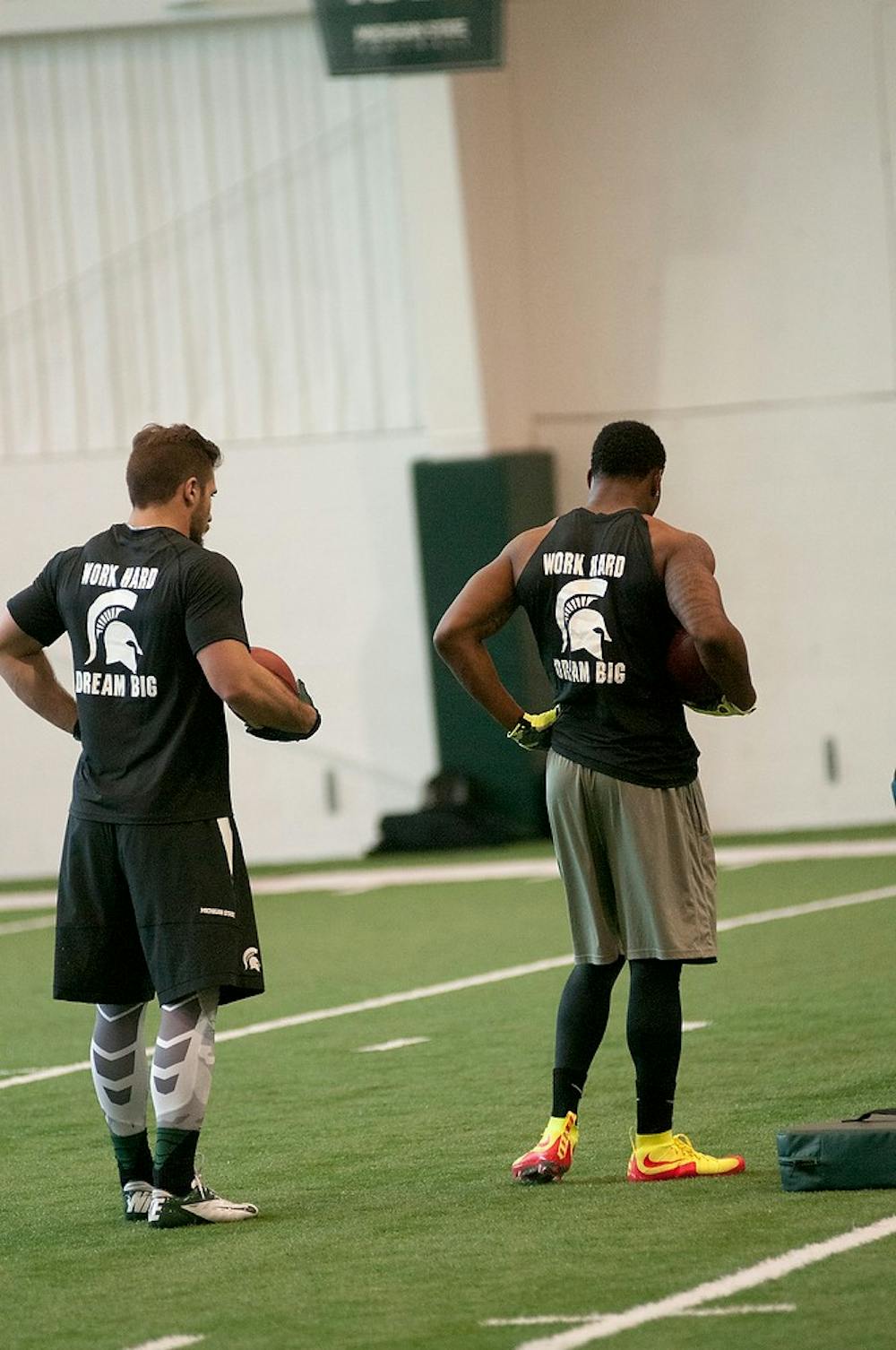 <p>Senior fullback Matt Rea, left, and  senior running back Jeremy Langord, right, catch their breath between drills Mar. 18, 2015, during Pro Day at the Duffy Daugherty Building. NFL scouts and coaches came to the event to check out Spartan NFL prospects. Kelsey Feldpausch/The State News</p>