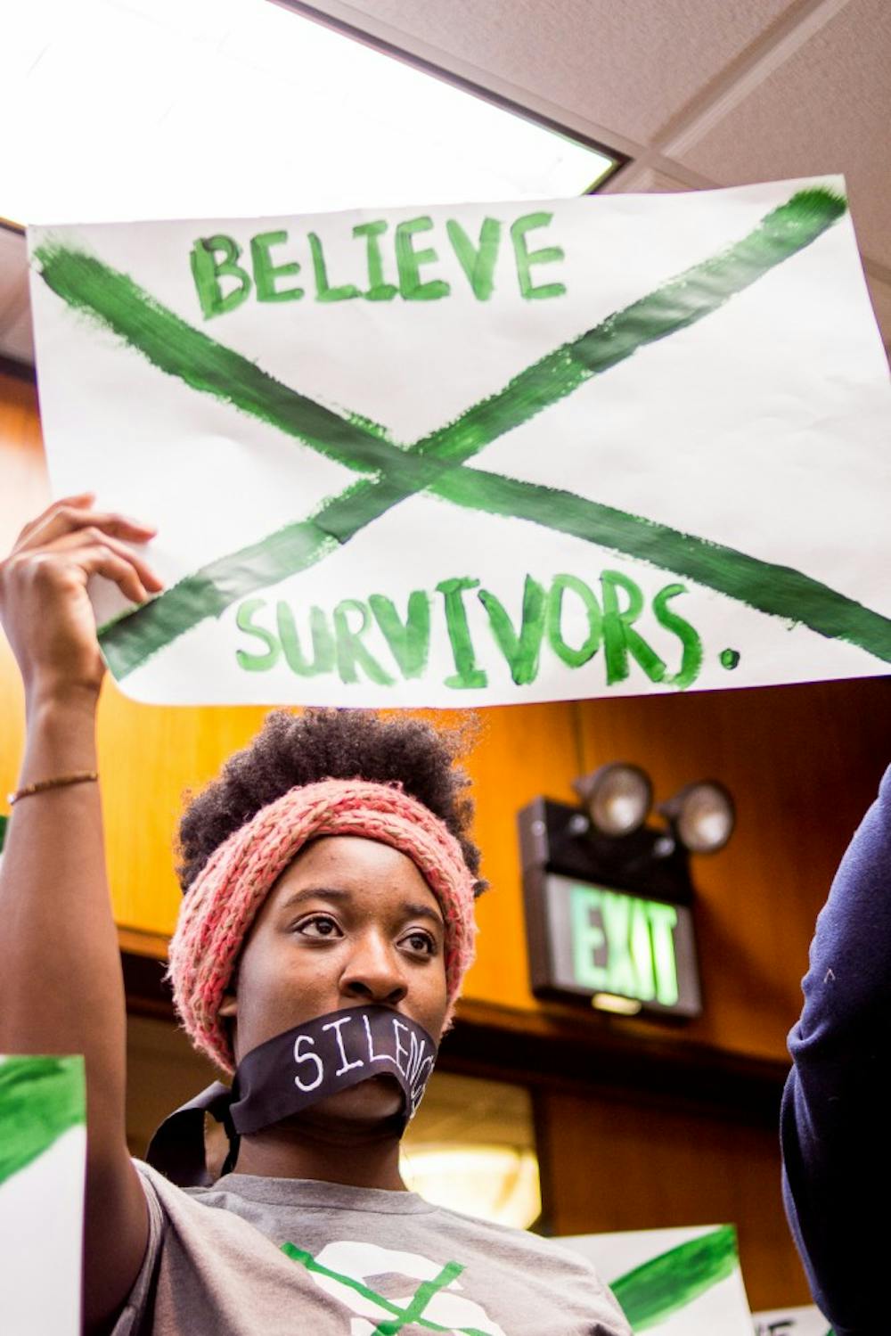 <p>Social relations and policy senior Ewurama Appiagyei-Dankah holds up a sign at a board of trustees meeting on Dec 15, 2017 at the Hannah Administration Building. Protesters gathered to address the misconduct of MSU’s handling of the Larry Nassar investigation.&nbsp;</p>