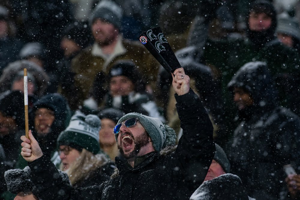 <p>A Spartan fan plays a cowbell and chants &quot;Go State&quot; during Michigan State&#x27;s win against Penn State on Nov. 27, 2021.</p>
