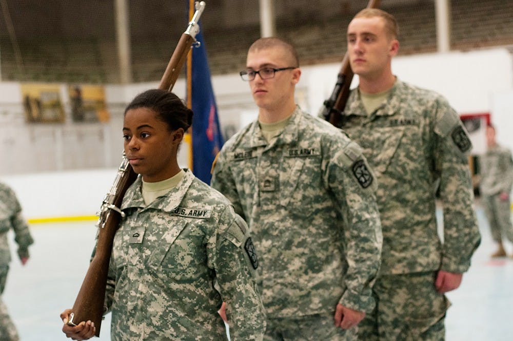 <p>From left, athletic training freshman Kristina Lewis, history junior Connor McLeod, and political science sophomore Duke Medema practice together during Army ROTC color guard practice Nov. 10, 2014, at Dem Hall. The MSU ROTC members will be at the MSU Alumni Memorial Chapel tomorrow for Veterans Day. Jessalyn Tamez/The State News </p>