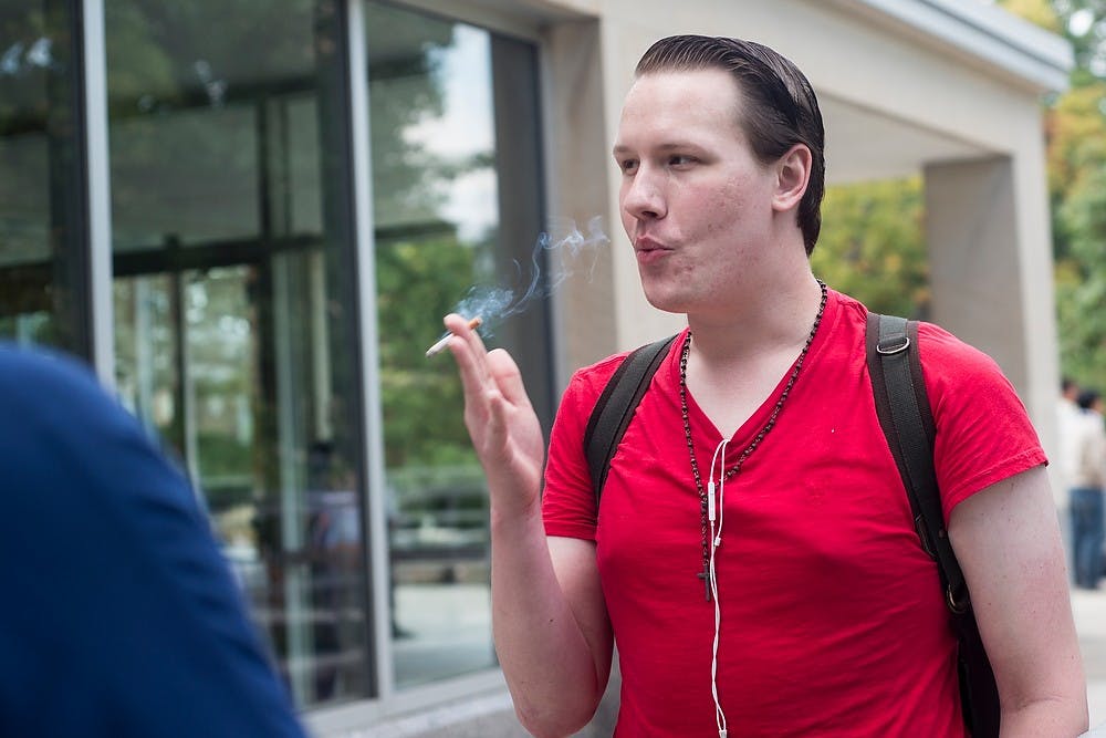 <p>Interdisciplinary studies in social science senior Tylor Bartley takes a cigarette break Sept. 29, 2014, between studying outside of the Main Library. Erin Hampton/The State News</p>