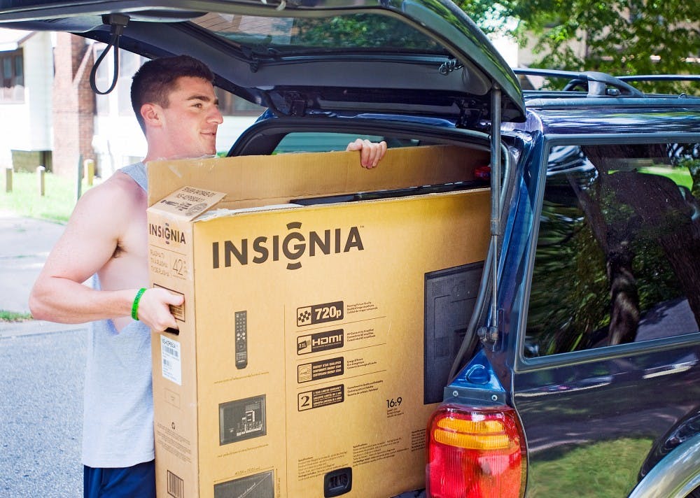 	<p>Business and marketing senior David Goodman helps carry a television into a house on Division Street Wednesday afternoon. Goodman is one of many students moving in early this month before the late-August rush, which is all too familiar to East Lansing locals.</p>