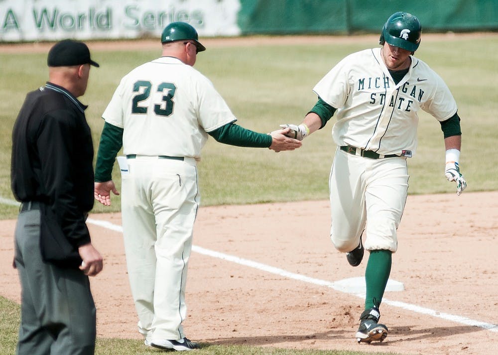 <p>Junior catcher/first baseman Blaise Salter high fives head coach Jake Boss Jr. after hitting a home run during the game against Siena on April 6, 2014, at McLane Baseball Stadium at Old College Field. The Spartans defeated the Saints, 5-1. Danyelle Morrow/The State News</p>
