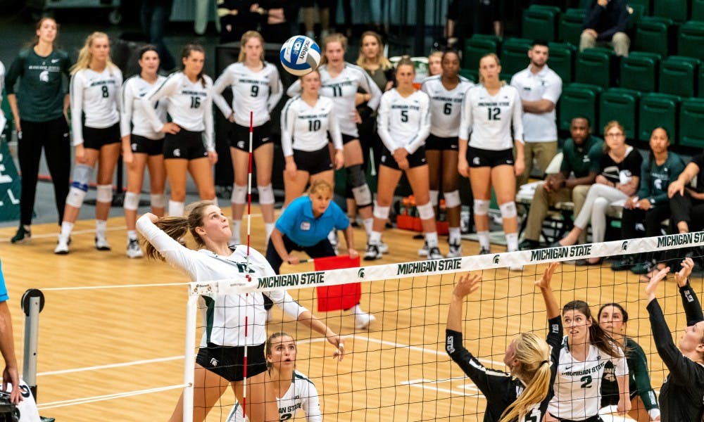 <p>Sophomore outside hitter Molly Johnson (left) lines up a spike against Oakland. The Spartans defeated the Golden Grizzlies, 3-0, at Jenison Field House on Sept. 12, 2019.</p>