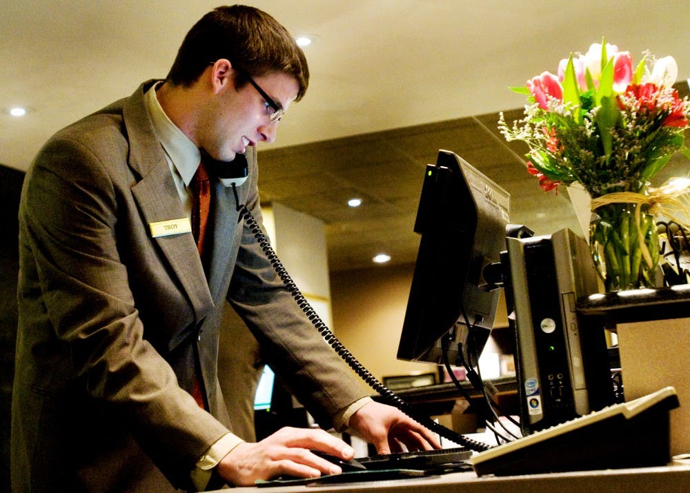 Senior hospitality business student Troy Walker takes a reservation Monday at Kellogg Hotel & Conference Center. Walker began working at the hotel 1 1/2 years ago and used it to fulfill his internship requirements. Jaclyn McNeal/The State News