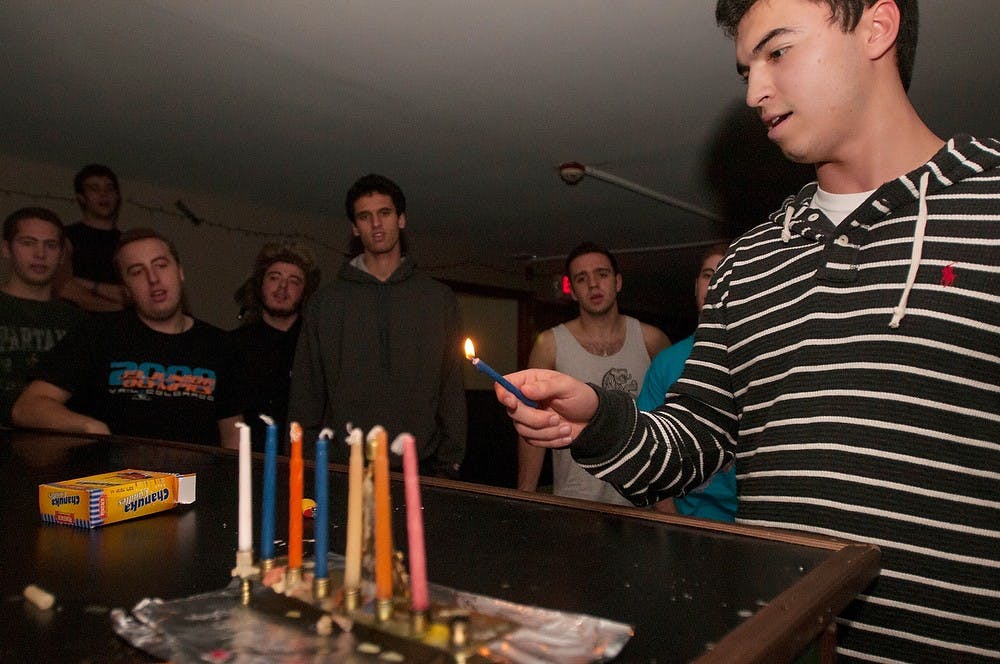 	<p>International relations sophomore Jess Goldblatt prepares to light a menorah with his brothers in Alpha Epsilon Pi fraternity on Dec. 3, 2013. This was the seventh night of Hanukkah represented by the seven candles in the menorah. Brian Palmer/The State News</p>