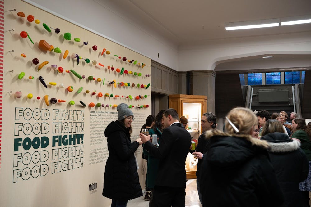 <p>MSU Museum staff speak to attendees of the Food Fight exhibition reception.</p>