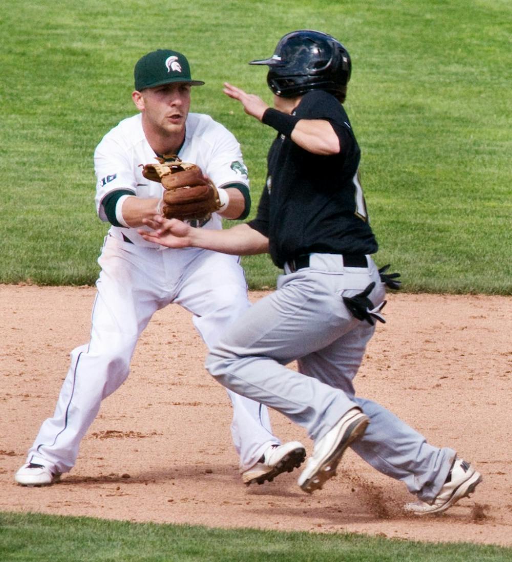 INF junior Ryan Jones tags out Oakland catcher Ian Yetsko during the baseball game Sunday against Oakland at McLane Baseball Stadium. The Spartans were victorious over Oakland 10-1. Derek Berggren/The State News