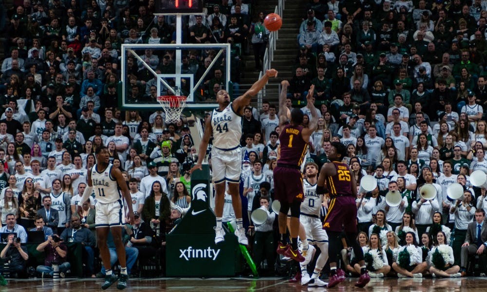 Junior forward Nick Ward (44) tries to block a shot from Minnesota's Dupree McBrayer. MSU beat Minnesota 79-55 at the Breslin Center on Feb. 9, 2019.