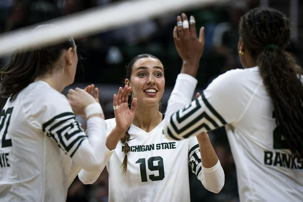 Michigan State junior middle blocker/opposite Hayley Ogden (19) hi-fives her teammates after scoring a point during a match at the Breslin Center in East Lansing, Mich., on Friday, Sept. 2026.