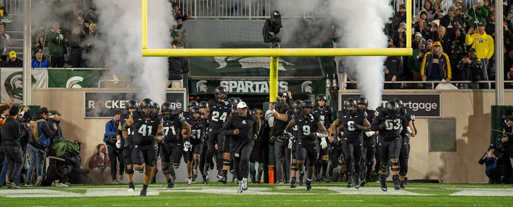 The MSU Football team runs out onto the field of Spartan Stadium led by Interim Head Coach Marlon Barnett prior to their game against the University of Michigan on Oct. 21, 2023. The Michigan State Spartans would go on to lose 49-0.