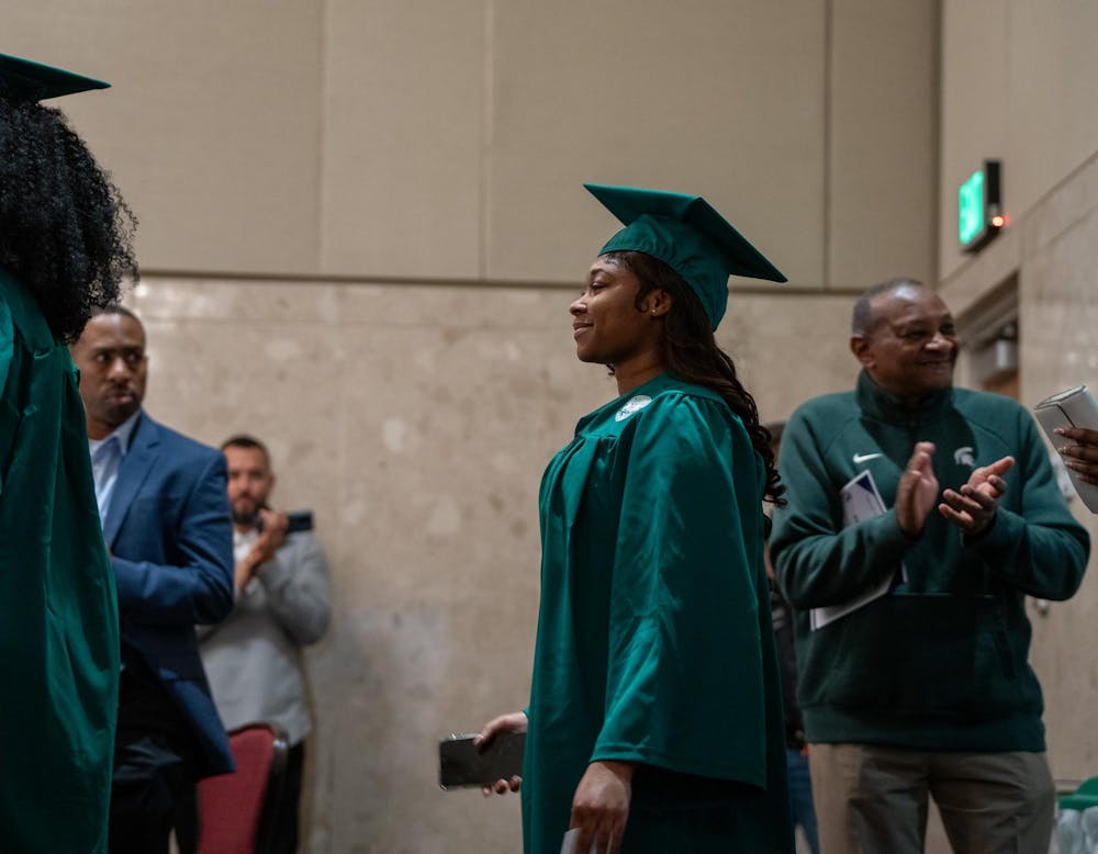 An MSU Fall 2023 graduate walks in while people cheer for her at the Fall 2023 Black Grad event at the Union Ballroom on Dec. 8, 2023. 