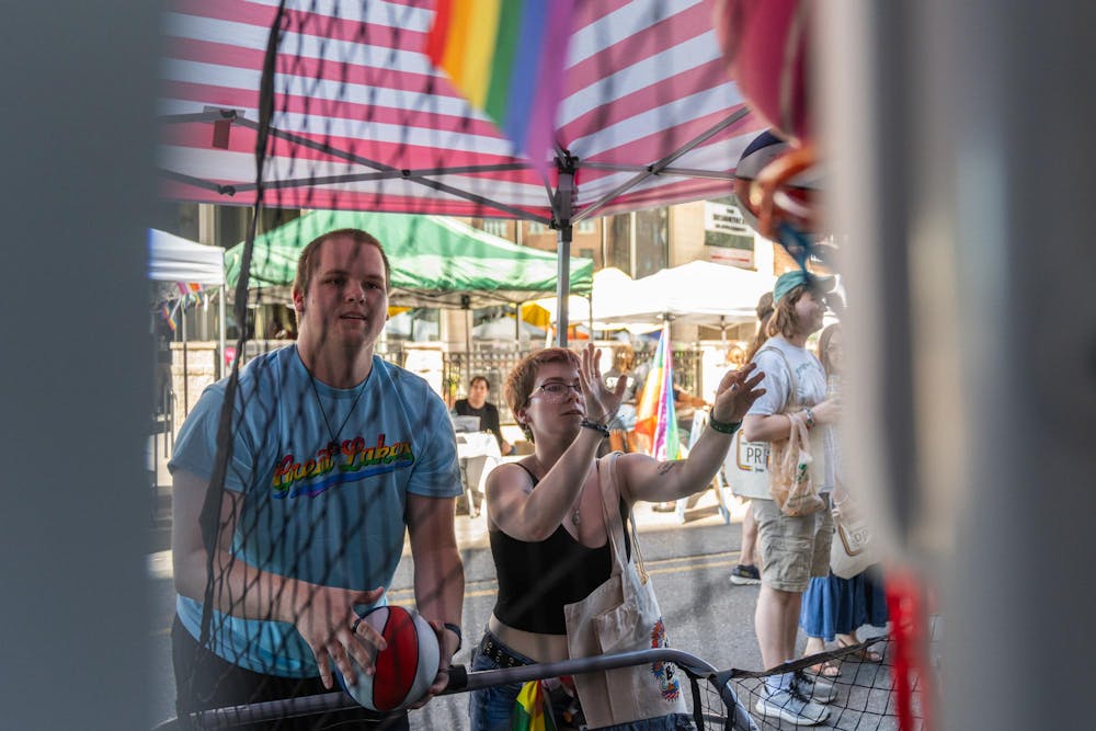 <p>Two East Lansing Pride attendees play a game of basketball at a booth to earn a prize in East Lansing, Mich., on June 13, 2026.</p>