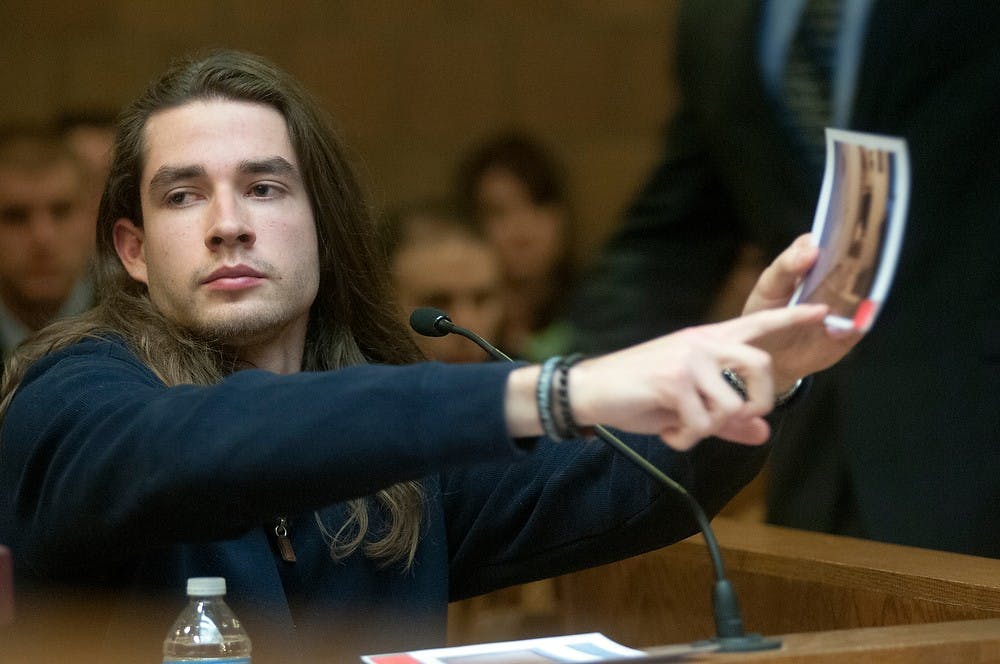 	<p><span class="caps">MSU</span> alumnus Tyler Aho, points to a piece of evidence during the preliminary exam for the teen accused of the fatal stabbing of <span class="caps">MSU</span> student Andrew Singler on April 18, 2013, at Ingham County District Judge Donald Allen&#8217;s courtroom in Mason, Mich. Aho was Singler&#8217;s roommate and witnessed the altercation. Natalie Kolb/The State News</p>