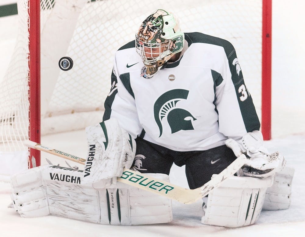 	<p>Junior goaltender Will Yanakeff stops a shot on Monday night, Oct. 8, 2012, at Munn Ice Arena. <span class="caps">MSU</span> defeated Windsor, 6-1in the first and only exhibition game. Adam Toolin/The State News</p>