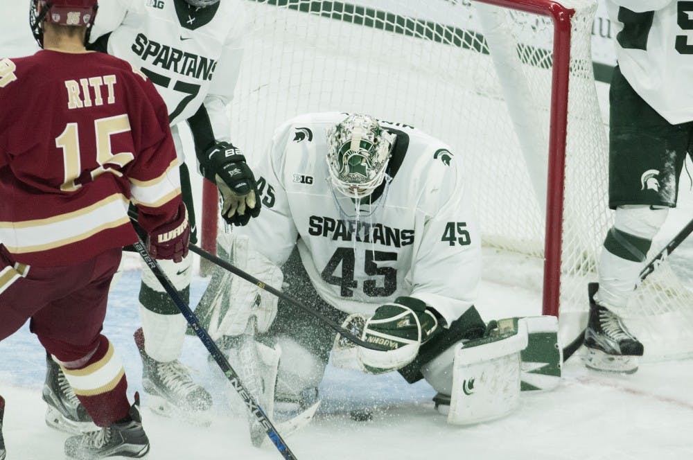 Junior goalie Ed Minney (45)  prepares to fall on the puck during the game against Denveron Oct. 21, 2016 at Munn Ice Arena.  The Spartans were defeated by the Pioneers, 2-1. 