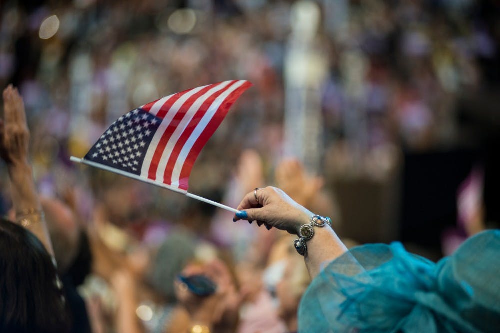 A delegate waves an American flag through the air on July 27, 2016, the third day of the Democratic National Convention, at Wells Fargo Arena in Philadelphia.