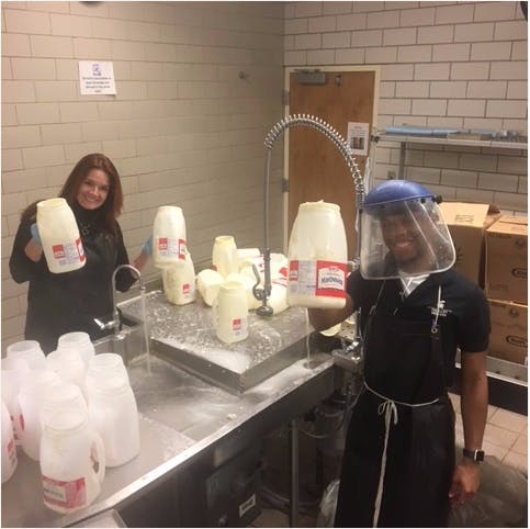 <p>RHS sustainability officer Carla Iansiti poses with sustainability department aid Nick Barnes while rinsing out mayonnaise containers in the Hubbard Hall kitchen. Photo courtesy of Cole Gude.</p>