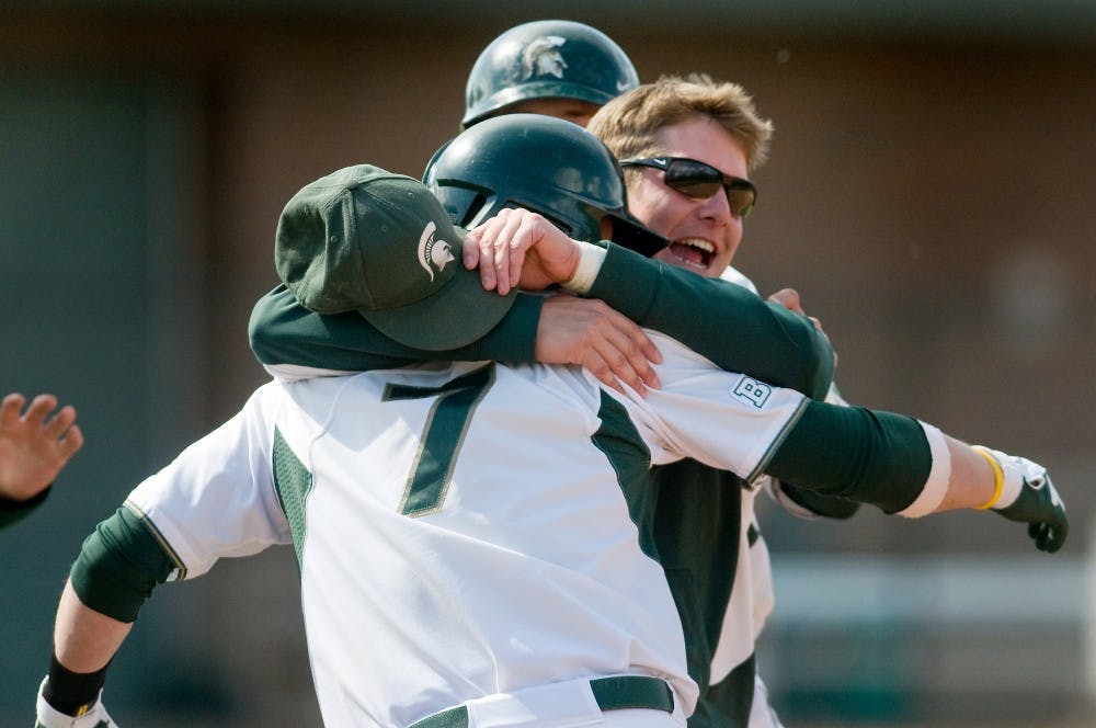 Spartan players embrace junior outfielder and infielder Torsten Boss after he made a game-winning bat. The Spartans defeated the Gophers by, 3-2 within 11 innings on Saturday afternoon at McLane Baseball Stadium at Old College Field. Justin Wan/The State News
