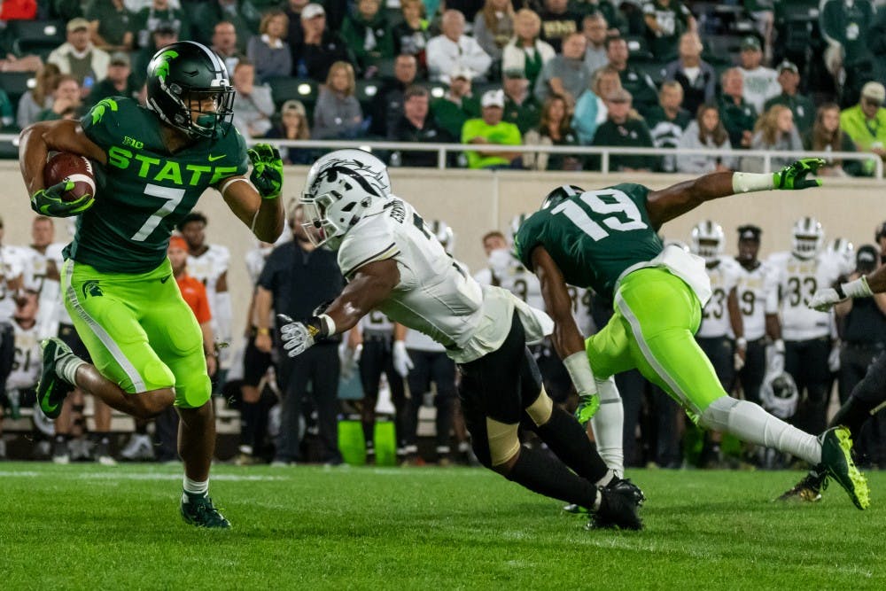 <p>Senior wide receiver Cody White (7) runs past a Western Michigan defender. The Spartans defeated the Broncos, 51-17, at Spartan Stadium on Sept. 7, 2019. </p>