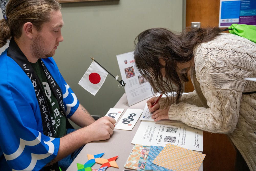 The Japan Center for Michigan Universities teaches a visitor how to write her name in Japanese at the Global Festival in the International Center on Nov. 16, 2024.