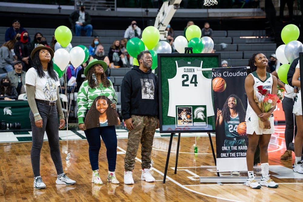 <p>Senior guard Nia Clouden (24) watches a celebration of her college career with her family. The Spartans held a ceremony honoring the four graduating seniors of the women&#x27;s basketball team at the Breslin Center on Feb. 27, 2022.</p>