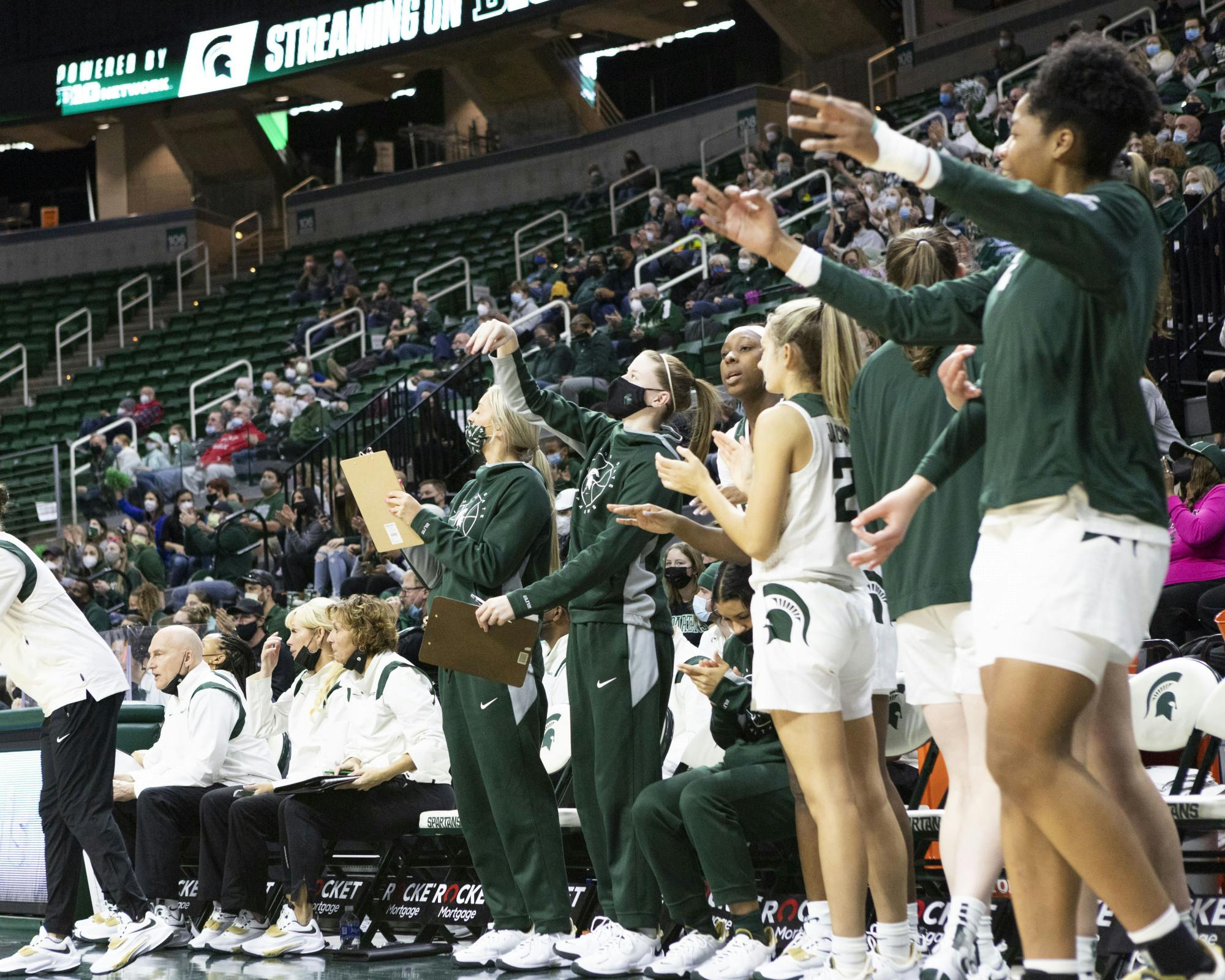<p>The Michigan State University Women’s basketball team and coaches cheers after their team scores on January 23rd, 2022.</p>
