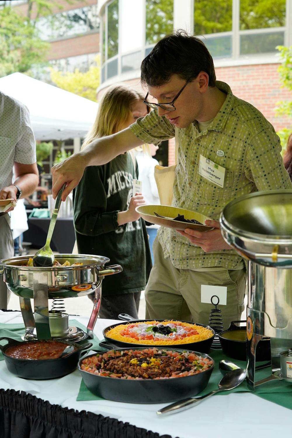 An attendee of the Excellence in Insect Science Symposium dishes up food on May 16, 2024.