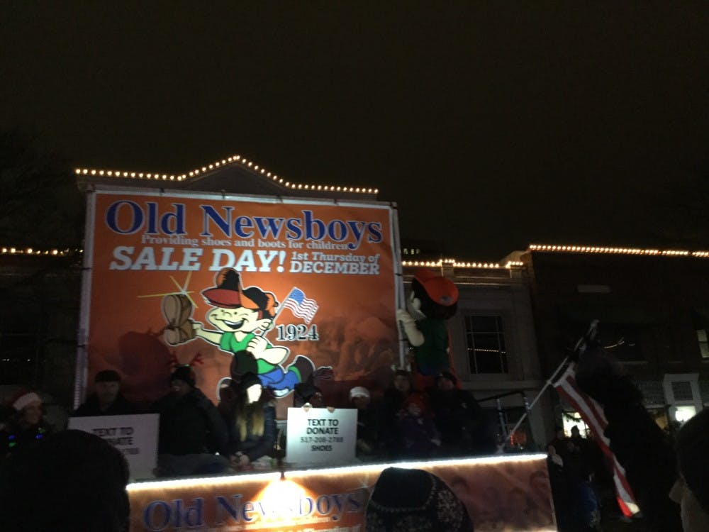 Members of the Old Newsboys ride their float in the 2018 Silver Bells in the City parade in Downtown Lansing. Photo by Maxwell Evans.