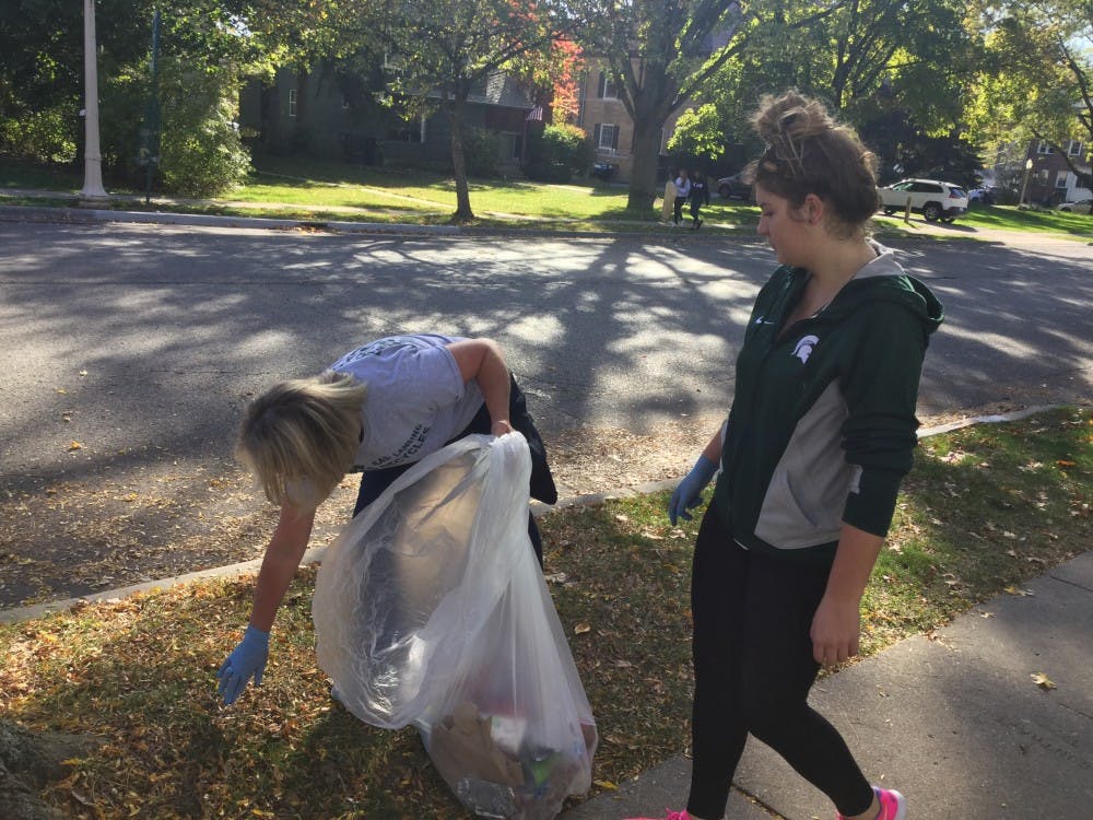 <p>Cathy DeShambo, left, East Lansing's environmental services administrator, picks up trash from the Bailey neighborhood on Oct. 22, 2017. DeShambo, along with her daughter, Rachel, participated in the final post-game neighborhood cleanup of the year, organized by the Community Relations Coalition.</p>