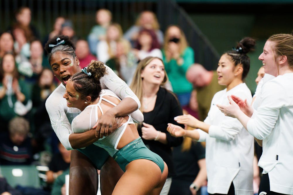 <p>Michigan State University gymnasts celebrate after a big floor routine performance puts them ahead of the University of Michigan. The Spartans hosted the No. 3 ranked Wolverines at Jenison Field House on Jan. 22, 2023, and upset with 197.200 points.</p>