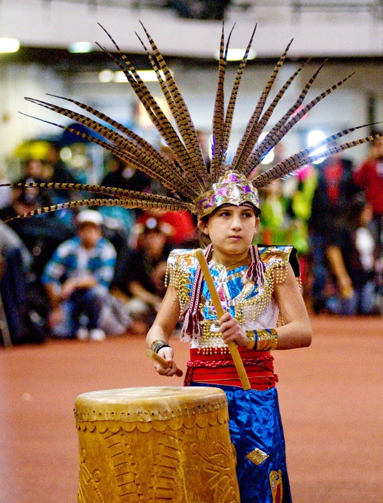 Reina Torrez-Miner, 12, plays a drum Saturday at Jenison Field House. Torrez-Miner was leading Dance Azteca, a group that dances in traditional Mexica style, an indigenous people from Mexico. The group was participating in the 28th annual Pow Wow of Love. Matt Radick/The State News