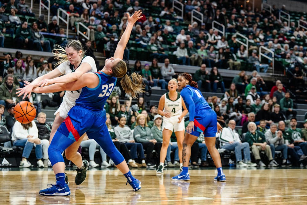 <p>MSU junior forward Grace VanSlooten (14) and DePaul graduate forward Jorie Allen (33) fight for the ball in the Breslin Center on Dec. 8, 2024.</p>