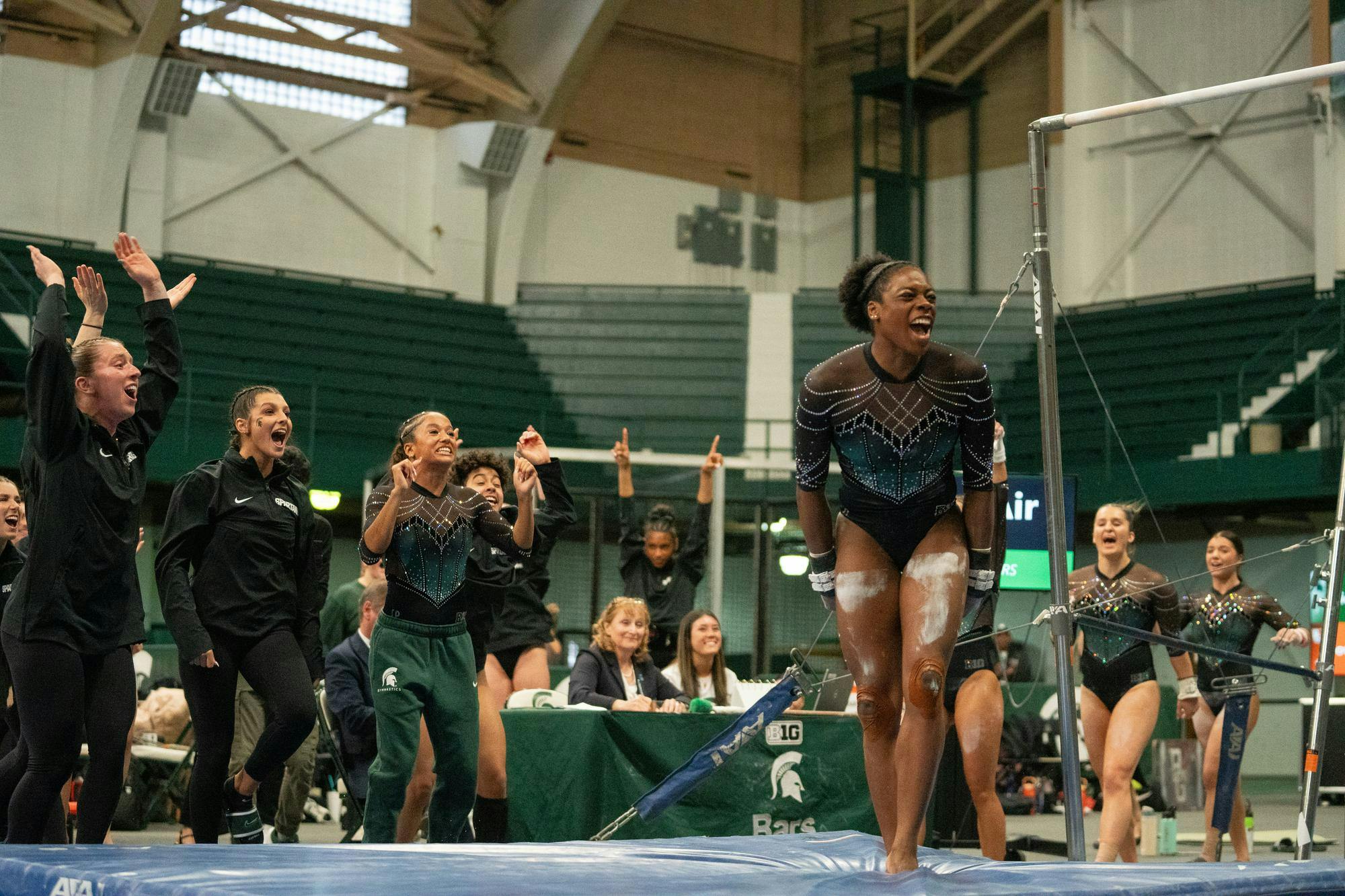 <p>Michigan State senior Gabi Stephen celebrates after completing her round on the uneven bars at Jenison Field House on March 16, 2025. Her Spartan teammates cheered her on after she scored a 9.990.</p>